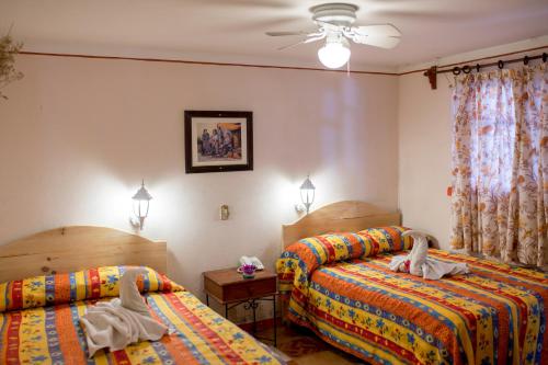 1 dormitorio con 2 camas y ventilador de techo en Arisa en Oaxaca de Juárez