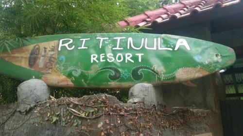 a sign that reads ritzulum resort with a surfboard at Ritinula Resort in Tejakula