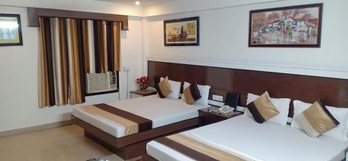 een hotelkamer met 2 bedden en een raam bij Hotel Su Shree Continental 5 Minutes Walk From New Delhi Railway Station in New Delhi