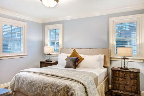 a bedroom with a bed with two night stands and two windows at Sonoma Bungalows in Sonoma
