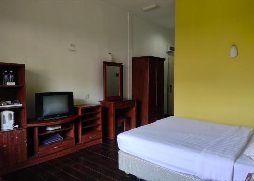 a bedroom with a bed and a tv in it at Nabalu Kundasang in Kundasang