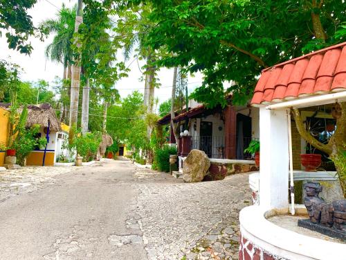 an empty street in a village with a building at Hotel Green River in Izamal