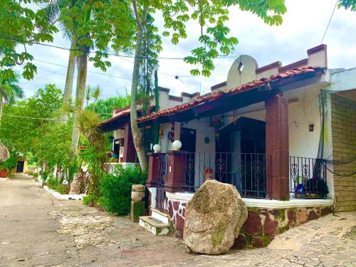 a house with a large rock in front of it at Hotel Green River in Izamal
