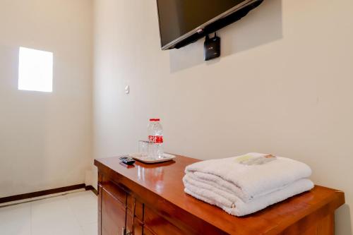 a bathroom with a wooden table with towels on it at Guesthouse Nusa Indah Syariah 2 in Batu