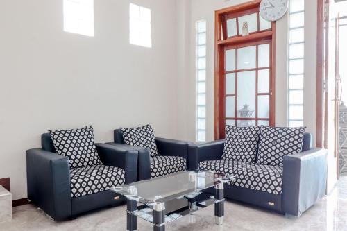 a living room with two blue couches and a table at Guesthouse Nusa Indah Syariah 2 in Batu