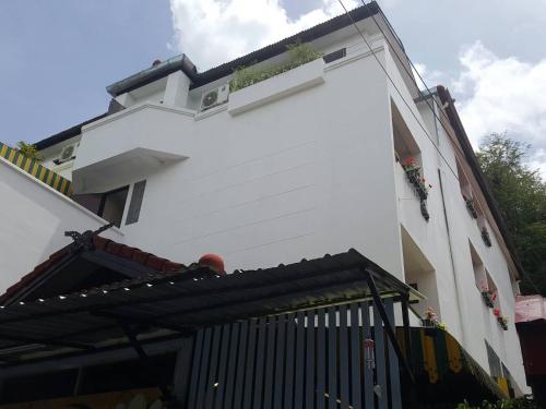 een wit gebouw met een zwarte poort ervoor bij V.I.P. House in Chiang Mai