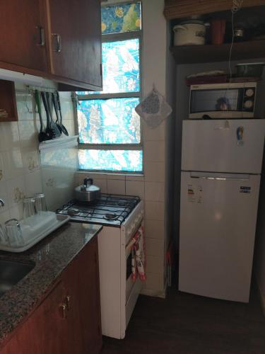 a small kitchen with a stove and a refrigerator at Edificio Aquarone in Piriápolis