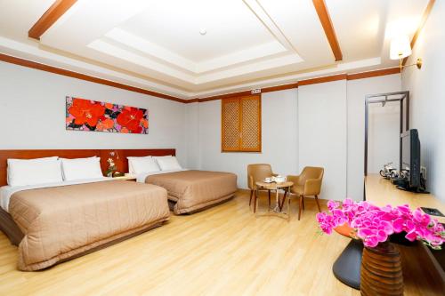 Cette chambre comprend 2 lits et une télévision. dans l'établissement Incheon Airport Hotel Queen, à Incheon