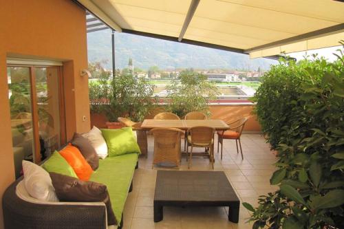 a patio with a couch and a table and chairs at Relax Suite in Merano