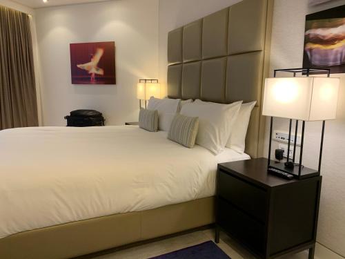 a bedroom with a large white bed with two lamps at Premium Class Marina Herzeliya in Herzliya B