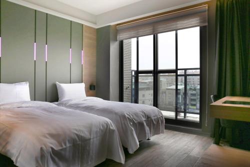 a bedroom with a bed and a large window at KIWI SHARE HOTEL ZHONGLI in Zhongli