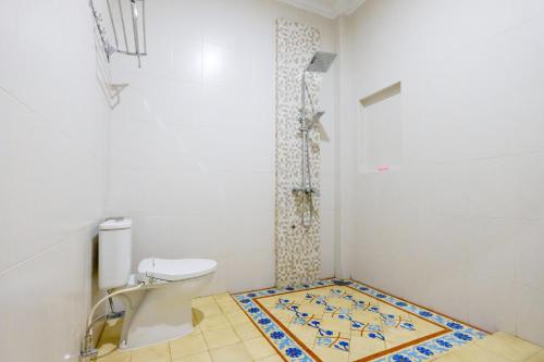 a bathroom with a toilet and a mosaic floor at SUPER OYO Collection O 2383 Andongkoe 64 Salatiga in Salatiga