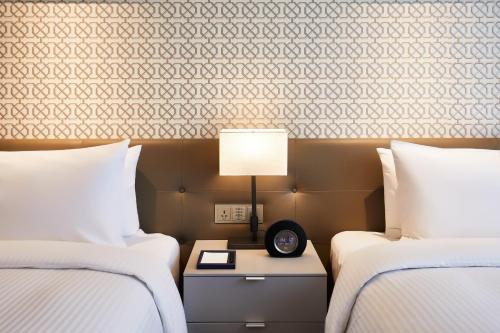 a hotel room with two beds and a lamp at Landing Jeju Shinhwa World Hotel in Seogwipo
