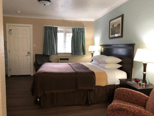 Un pat sau paturi într-o cameră la Value Inn Motel EUGENE AIRPORT