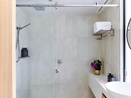 uma casa de banho com um chuveiro e um lavatório. em Crystalbrook Flynn em Cairns