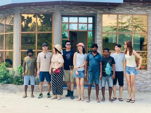 a group of people standing in front of a building at Hudhuvelimaldives in Omadhoo