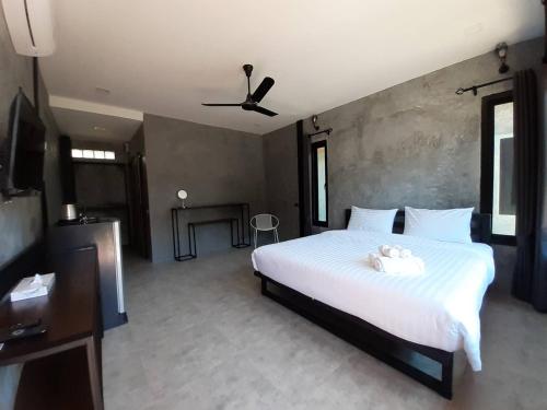 a bedroom with a large white bed with a ceiling at BaanKampu Resort in Pak Chong