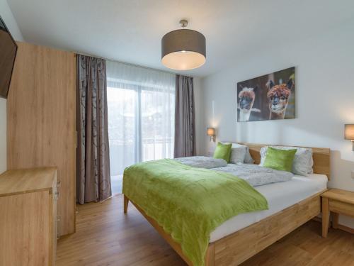 sypialnia z dużym łóżkiem i zielonym kocem w obiekcie Appartement Strasser w mieście Söll