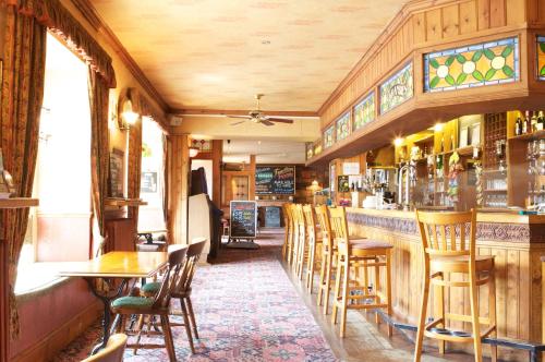 a restaurant with a bar with chairs and tables at Radstock Hotel near Bath in Radstock