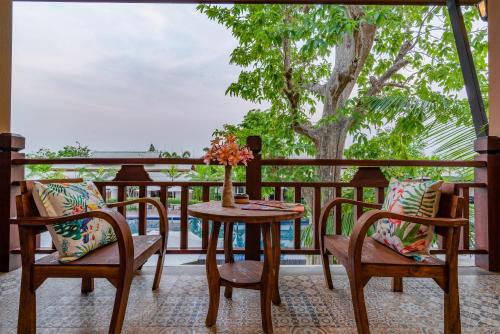 a table and chairs on a balcony with a view of the ocean at Lanna Deer Resort Chiang Mai in Chiang Mai