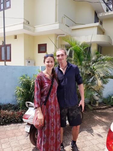a man and a woman standing in front of a house at Sun n Tan Beach Home stay in Kannur