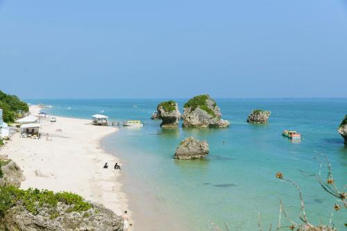 a view of a beach with rocks in the water at 姉と弟の家 in Nanjo