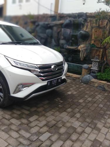 a white car parked in front of a fountain at Bromo Otix Guest House in Bromo
