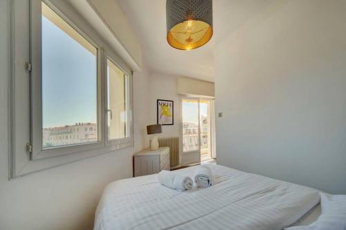 une chambre avec un grand lit blanc avec une fenêtre dans l'établissement Le Maria - Cannes - Renovated Feb 2025, à Cannes