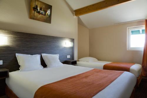 a hotel room with two beds and a window at The Originals City, Hôtel L'Acropole, Saint-Etienne Sud in La Ricamarie