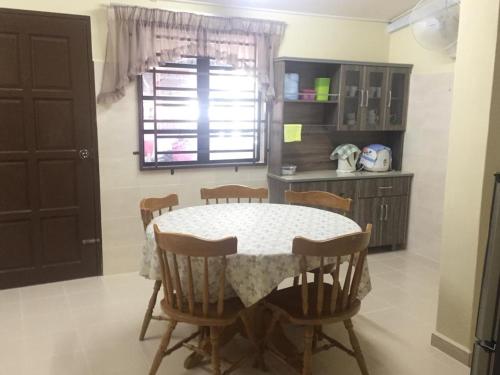 a kitchen with a table and chairs in a room at WARDAH HOMESTAY in Kampong Gong Badak