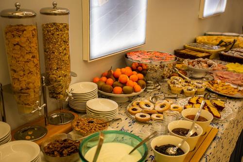 una tavola ricoperta di piatti e ciotole di cibo di Hotel Nuovo Al Mare ad Alassio