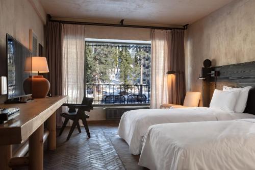a hotel room with two beds and a desk and a window at Rooms Hotel Kokhta in Bakuriani