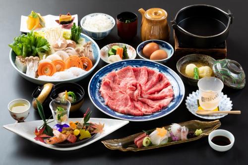 a table with many plates of food on it at Yufuin Santoukan in Yufuin