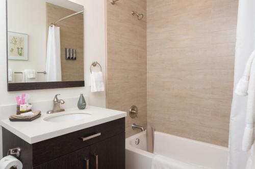 a bathroom with a sink and a tub and a mirror at Hotel Flora and Fauna in Wimberley