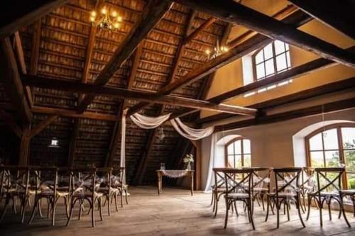 a large room with tables and chairs in a building at Penzion Jízdárna Hejtmánkovice in Broumov