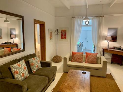 a living room with a couch and a table at The Missions House in Hermanus