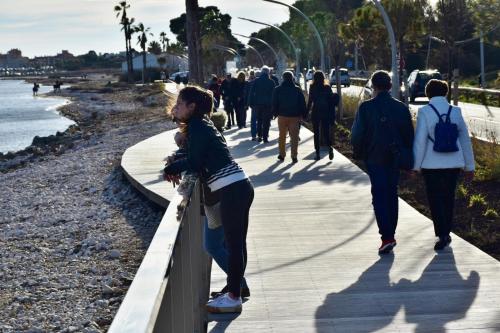a group of people walking on a sidewalk near the beach at Hotel Club Le Plein Sud Vacances Bleues in Hyères