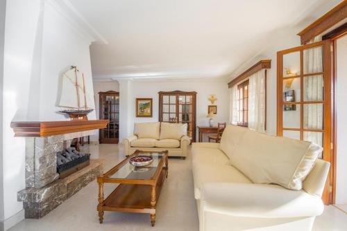 a living room with two couches and a fireplace at Casa Can Pou in Cala Millor