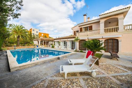 a villa with a swimming pool and a house at Casa Can Pou in Cala Millor