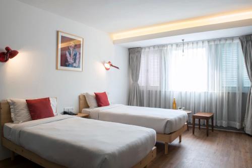 a hotel room with two beds and a window at Potala Guest House in Kathmandu