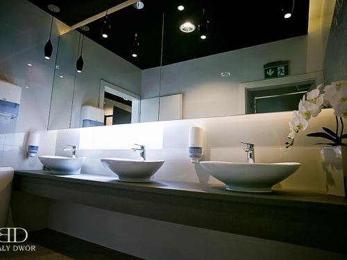a bathroom with three sinks in front of a mirror at Biały Dwór in Rychwał