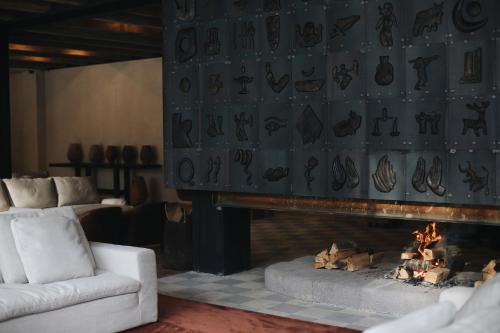 a living room with a fireplace and a white couch at Kokhta Bakuriani in Bakuriani