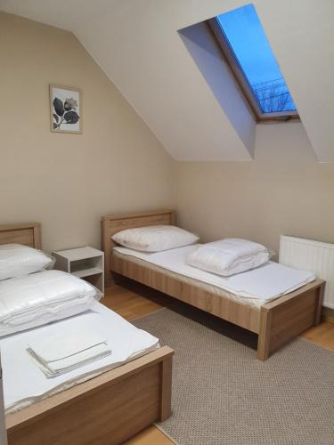 two beds in a room with a skylight at Bella Apartman in Szeged