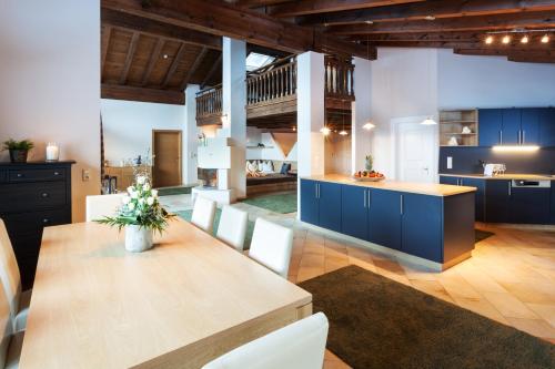 a large kitchen with a wooden table and blue cabinets at Sporthotel Cristall in Fulpmes