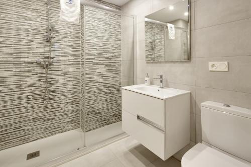 a bathroom with a toilet and a sink and a shower at Koxka - Basque Stay in San Sebastián