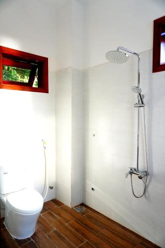 a bathroom with a toilet and a shower at Monkey Homestay & Bar in Tân Hiệp