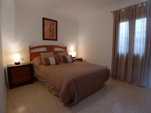 a bedroom with a bed with two night stands and two lamps at Torrox Beach Club in Torrox Costa