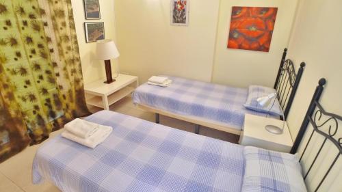 Cette chambre comprend deux lits, une table et une lampe. dans l'établissement Torresol, à Nerja