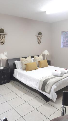 a bedroom with a large white bed with pillows at Zeezicht Holiday Guest Unit in Franskraal
