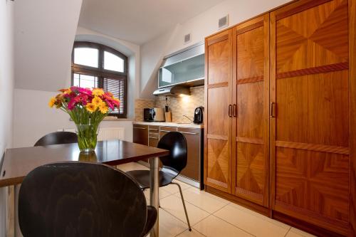 Una cocina con una mesa con un jarrón de flores encima. en Red Brick Apartments, en Cracovia